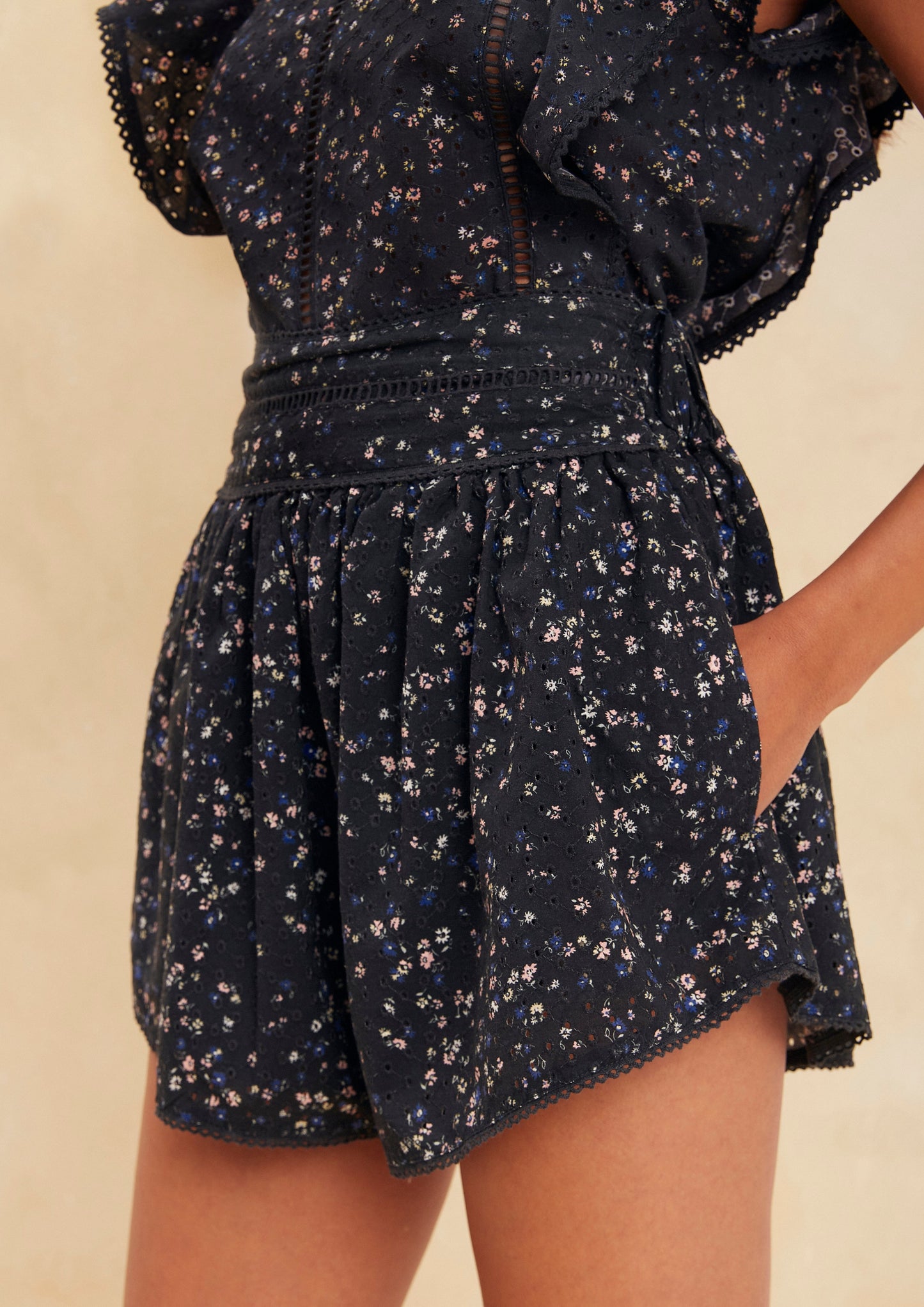 MAIA BERGMAN Get ready to elevate your summer wardrobe with the best-selling Shani set! This adorable set features a top with frills and back buttons, paired with shorts that boast a comfortable elastic waistband and practical pockets. Made of breathable cotton, this set is both cute and functional. It's the perfect choice for minimal effort dressing, as it requires little styling to achieve a perfect outfit.